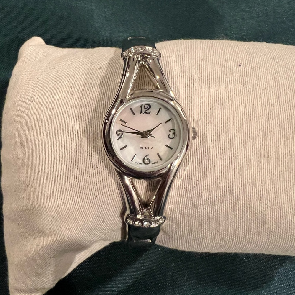 Quartz opal face silver tone ladies bangle watch.